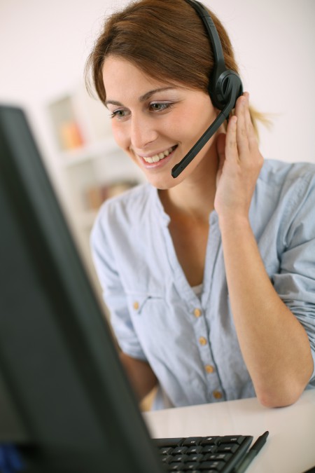 Young woman at work talking on phone with headset